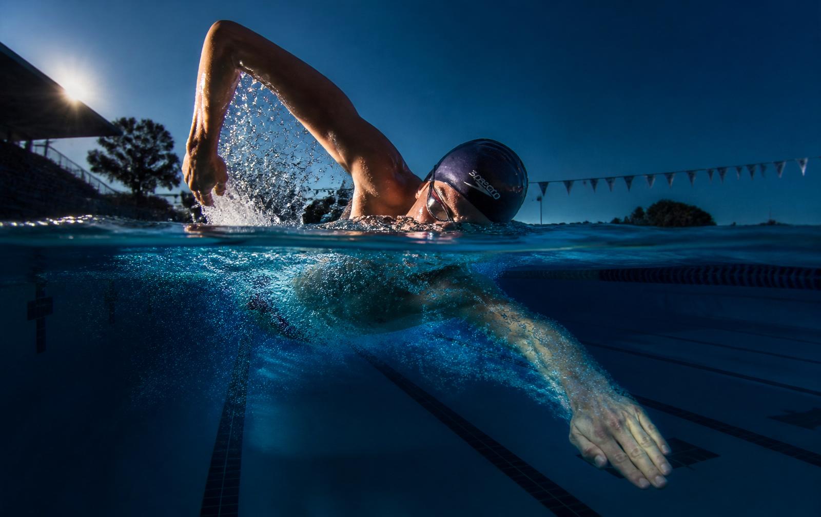Split over/under photograph of a freestyle swimmer at the catch